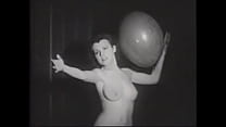 Erotic retro model with a beautiful figure plays with balloons for the crowd on stage